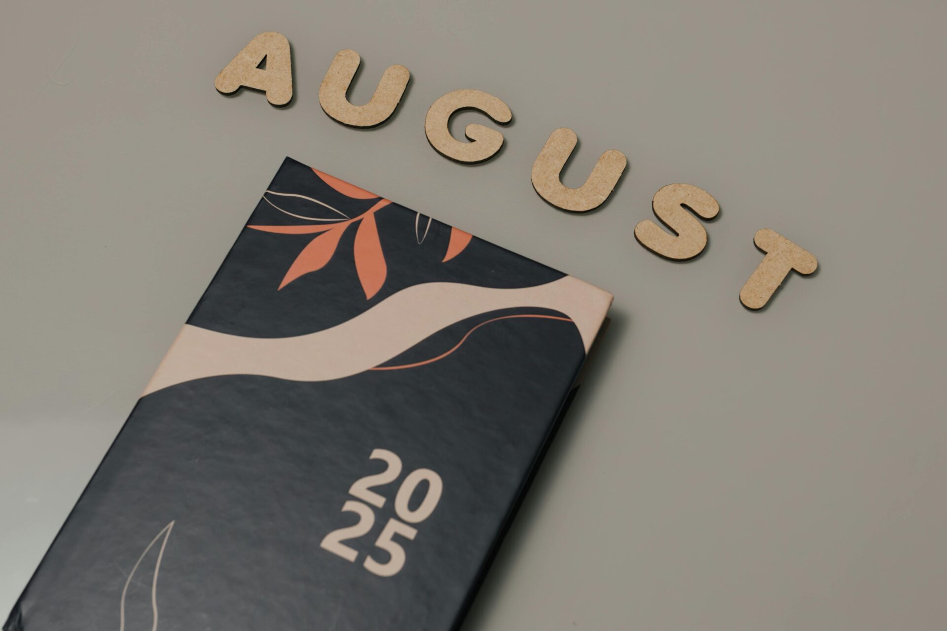 Eleganter Planer 2025 mit dekorativem Einband und August-Holzbuchstaben.