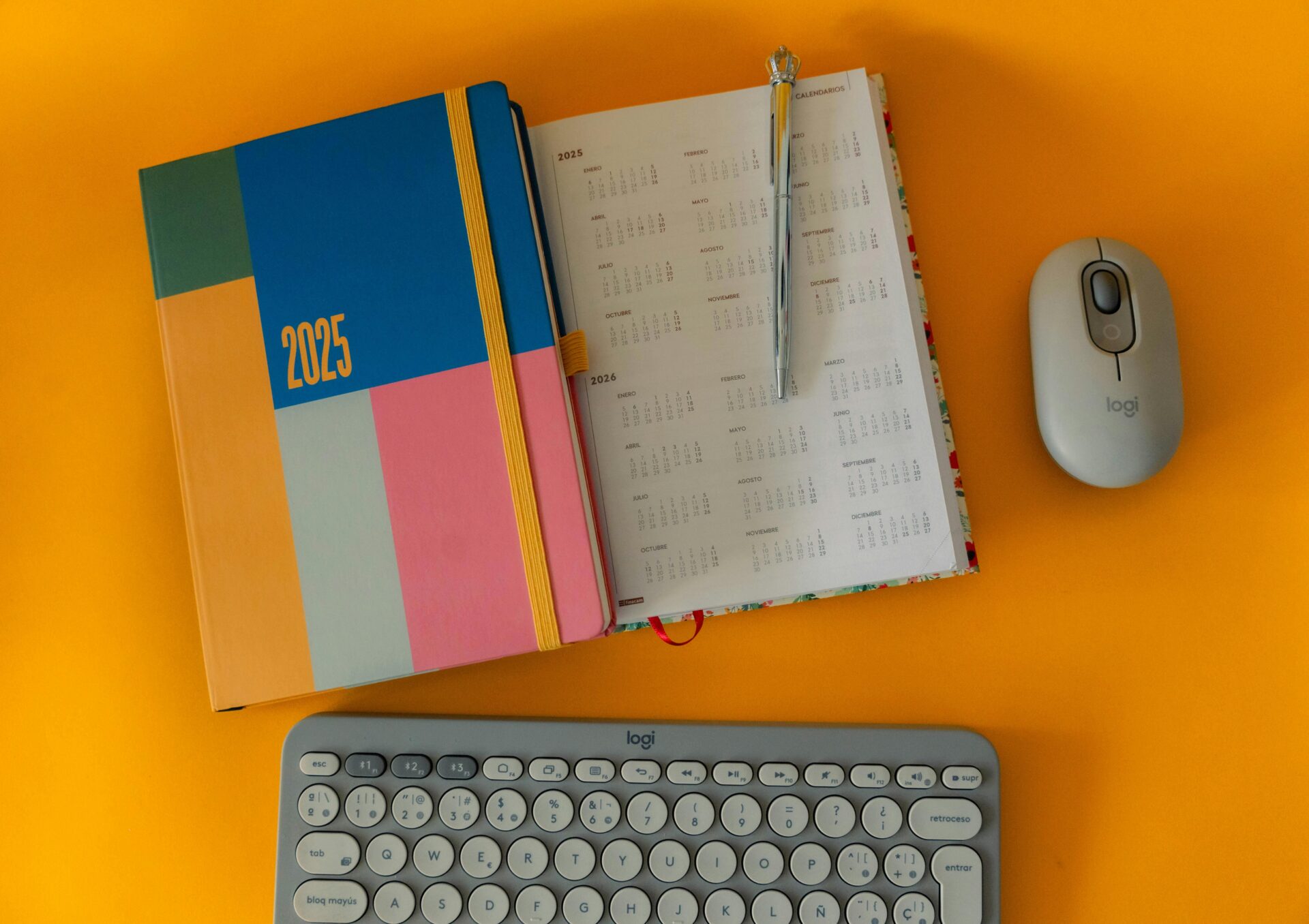 Bunter Planer f&Atilde;&frac14;r 2025 mit Tastatur und Maus auf hellem Hintergrund zur Organisation.