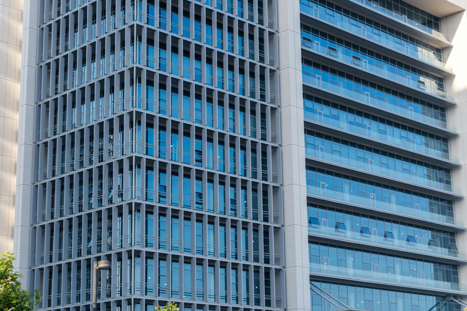 Nahaufnahme eines modernen Hochhauses mit einer Glasfassade mit Reflexionen.