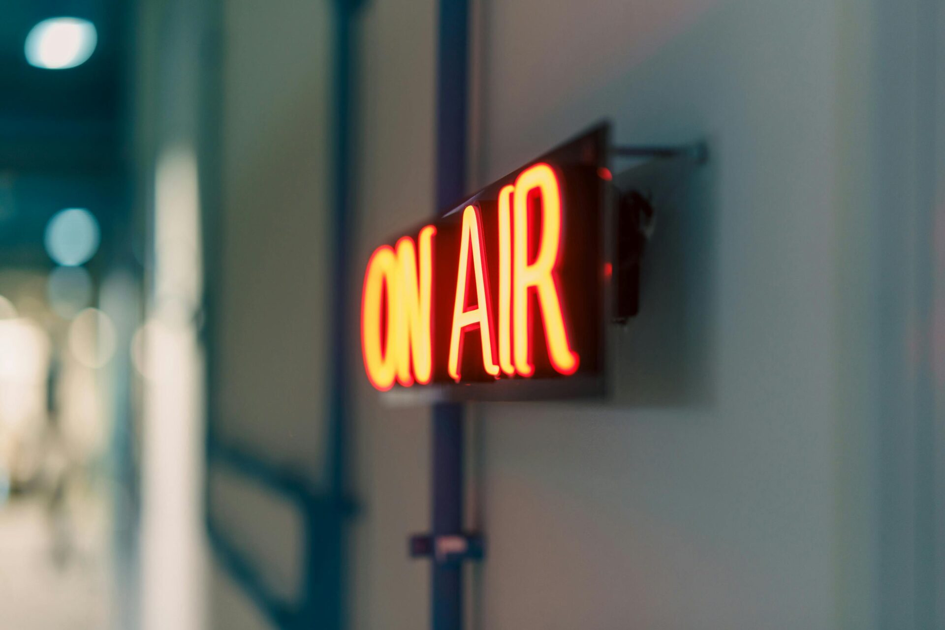 Leuchtend rotes „On Air“-Neonschild im Innenbereich, ideal für Medieninhalte.